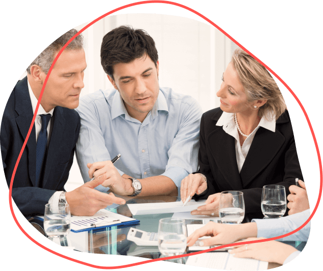 Štyria profesionáli z benefitnej spoločnosti sa stretávajú pri stole, obklopení dokumentmi a pohármi vody.