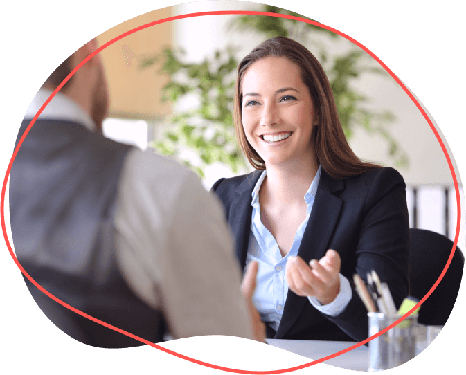 Žena v saku sa usmieva a gestikuluje pri diskusii o účtovnom poradenstve s mužom v kancelárskom prostredí.