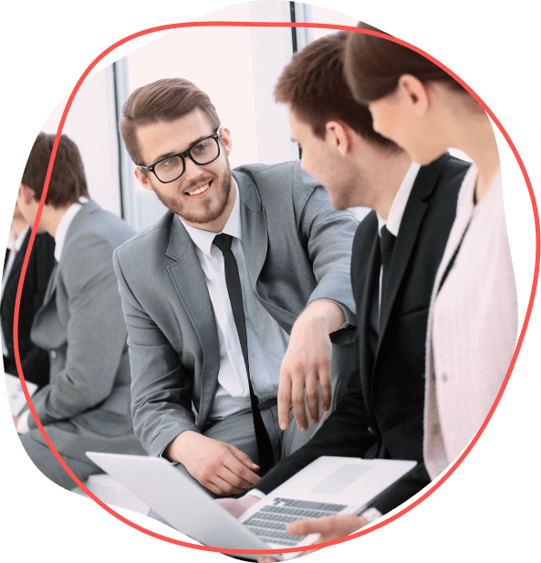 V interiéri sedia traja ľudia v profesionálnom oblečení. Dvaja majú notebooky a rozprávajú sa o výhodách pre zamestnancov, skúmajú nové možnosti rastu a spokojnosti zamestnancov.