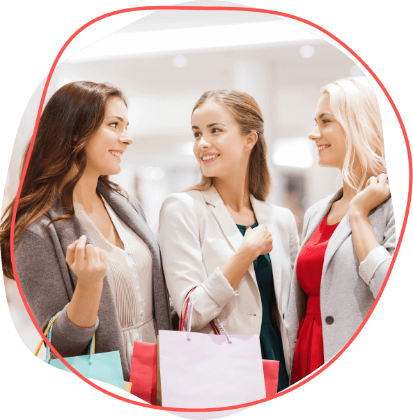 Tri ženy v biznis neformálnom oblečení sa usmievajú a držia nákupné tašky v obchode a vychutnávajú si pôžitky Zľavového sveta.